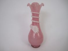 a pink vase sitting on top of a white table