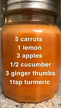 a jar filled with orange liquid sitting on top of a counter