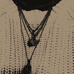 a black and white photo with three necklaces hanging from it's neckline