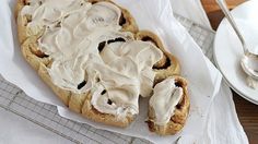 a pastry with white icing sitting on top of a table next to a plate