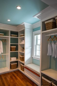 an empty walk - in closet with clothes hanging on the shelves and baskets under them