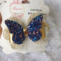 a blue and gold bow with sequins on it sitting on a white card