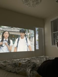 two people are watching television in the bedroom