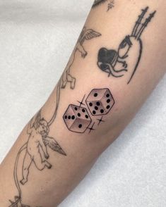 a person with a tattoo on their arm holding two dices