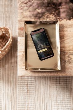 a cell phone sitting in a box on top of a table next to a basket