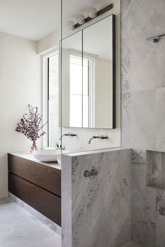 a bathroom with marble counter tops and a large mirror on the wall above the sink