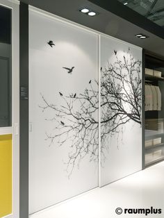 there are birds flying over the trees on this glass wall in front of closet doors