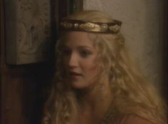 a woman with long blonde hair wearing a crown