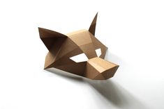 an origami dog mask made out of cardboard on a white surface with one eye open