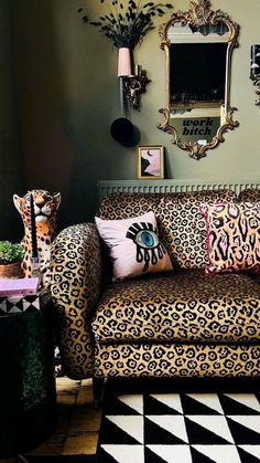 a leopard print couch in a living room with decorative items on the table and pictures on the wall