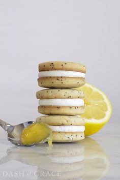 a stack of cookies with lemon wedges and a spoon next to it on a reflective surface