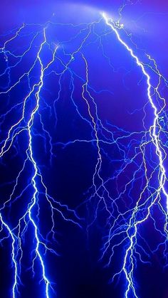 lightning strikes in the night sky with blue and purple lighting on it's sides