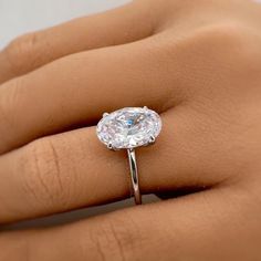 a woman's hand with a ring on it and a diamond in the middle