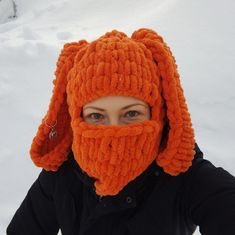 a woman wearing an orange knitted hat with a beard on it's head