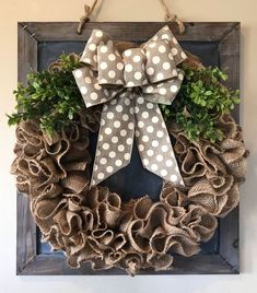 a wreath hanging on the wall with polka dots and greenery in front of it