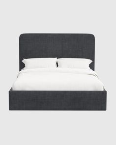 an upholstered bed with white linens and black headboard, in front of a gray background