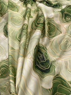 the fabric is green and white with swirls on it