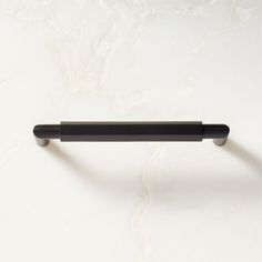 a black drawer handle on a white surface