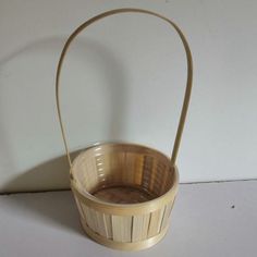 a wooden basket sitting on top of a white table next to a wall and floor