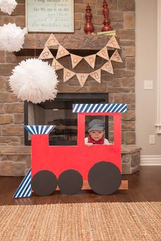 a child's birthday party with a train theme and paper pom poms