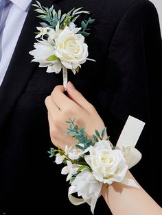 a man and woman wearing boutonnieres with white flowers on their lapels