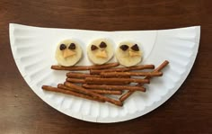 a paper plate topped with pretzels and birds on top of each other next to crackers