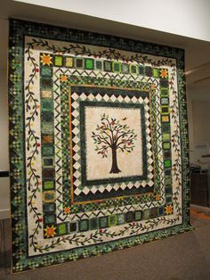 a quilted wall hanging with a tree on it