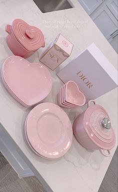 the pink dishes are on the table next to the box and other items that have been placed around it