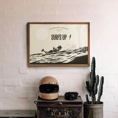 a helmet sitting on top of a wooden chest next to a potted cacti