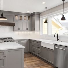 a kitchen with gray cabinets and white counter tops