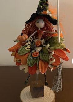 a doll is holding a flag on top of a wooden stand with leaves and pumpkins