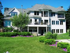 a large white house sitting on top of a lush green field