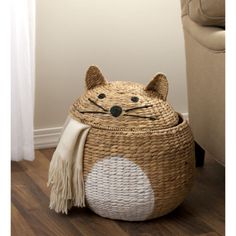 a cat shaped basket sitting on top of a wooden floor