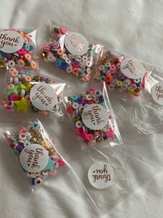 there are many bags with different buttons in them on the bed and one is filled with confetti or sprinkles