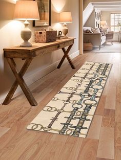 a hallway with wooden flooring and lamps on either side of the hall table, along with a rug that has an ornate design