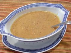 a white bowl filled with brown liquid on top of a table