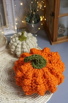 two crocheted pumpkins sitting on top of a table