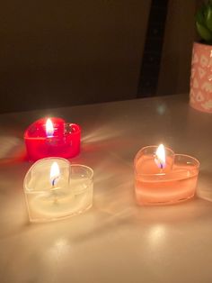 three lit candles sitting on top of a table