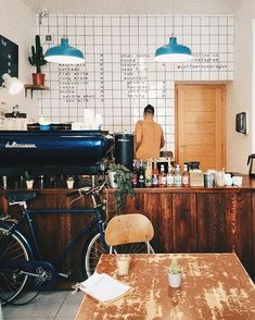 a man standing in front of a kitchen counter next to a bike parked up against the wall