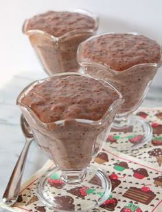 three desserts in small glass dishes on a table