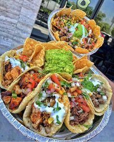 several tacos are on a plate with guacamole and salsa