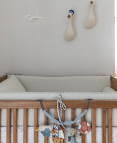 a baby crib with two wooden spoons hanging from it's hooks on the wall