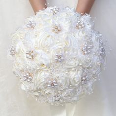 the bride's bouquet is made up of white flowers and pearls