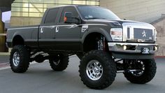 a large black truck parked in front of a building