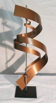 a metal sculpture on a black stand with a white background and some light brown strips