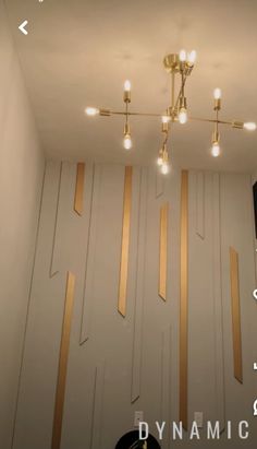 a room that has some lights on the ceiling and gold trimmings around it