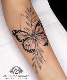 a black and white butterfly tattoo on the right arm, with leaves around it's wings