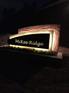 the entrance sign to mckee ridge is lit up at night with its lights on