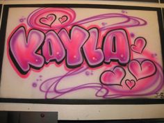 the word kayla is painted in pink and purple with hearts on it's side