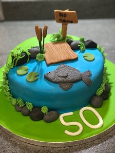 there is a cake that has been decorated to look like a fish and the number 50 on it